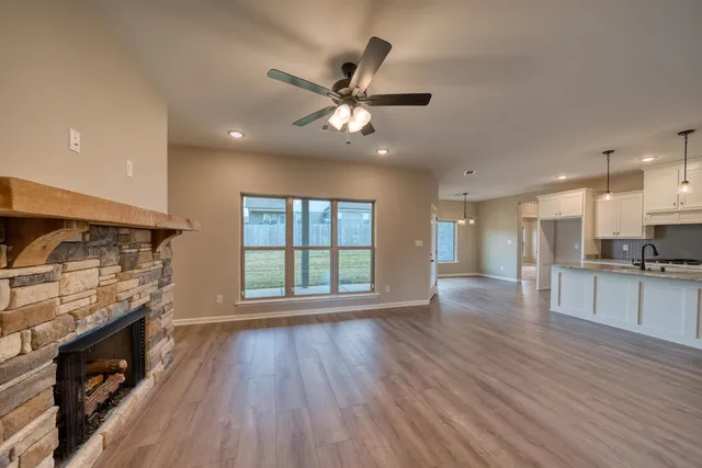 a view of an empty room with a kitchen and a stove top oven
