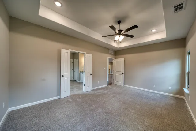 an empty room with closet and a ceiling fan