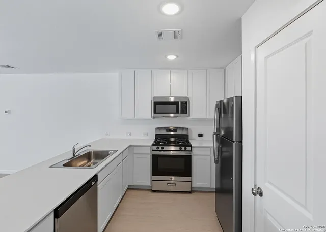 a kitchen with stainless steel appliances a refrigerator stove and microwave