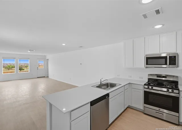a kitchen that has a sink and a stove top oven