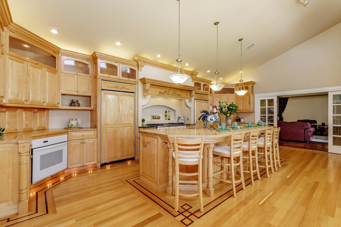 20585 Scofield Drive Cupertino, CA 95014 - Photo 15 of 32 a view of a kitchen with kitchen island granite countertop a refrigerator a stove top oven a dining table and chairs with wooden floor