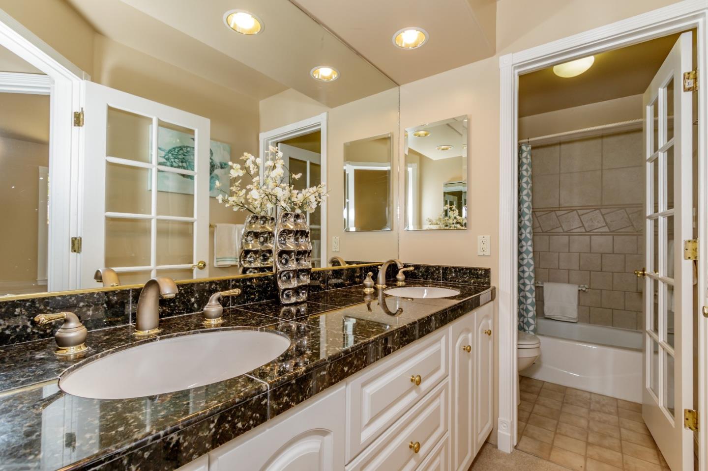 20585 Scofield Drive Cupertino, CA 95014 - Photo 27 of 32 a bathroom with a granite countertop sink and a mirror