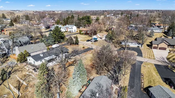 a view of a backyard with wooden fence and large trees