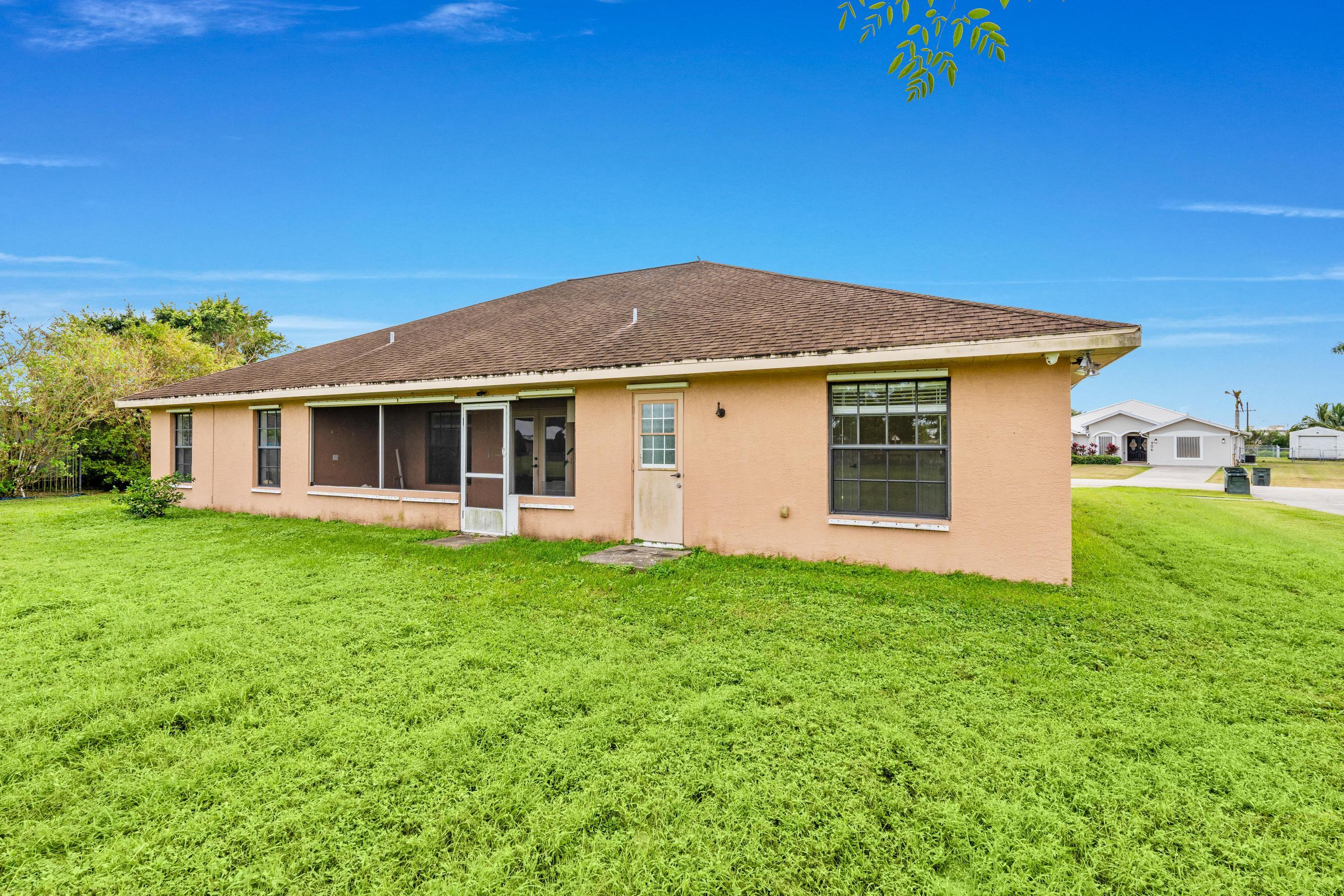 907 Sawgrass Street Clewiston, FL 33440 - Photo 25 of 60 a front view of a house with a yard