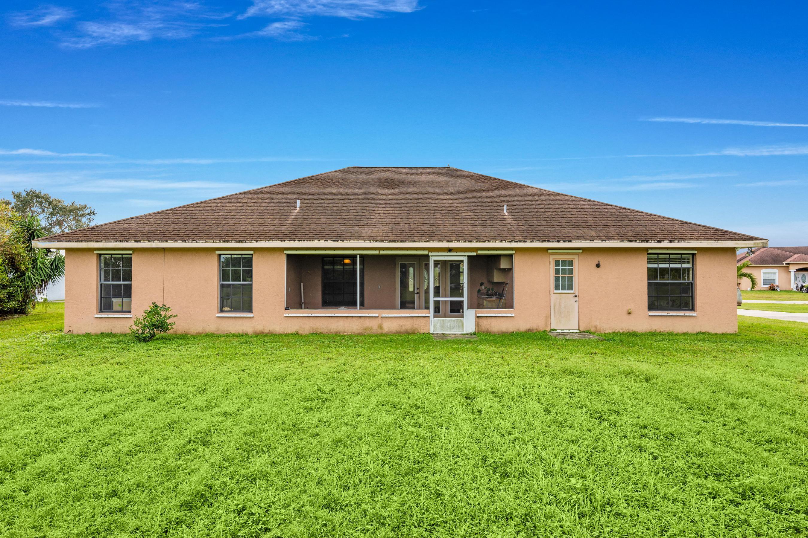 907 Sawgrass Street Clewiston, FL 33440 - Photo 26 of 60 a front view of a house with a garden