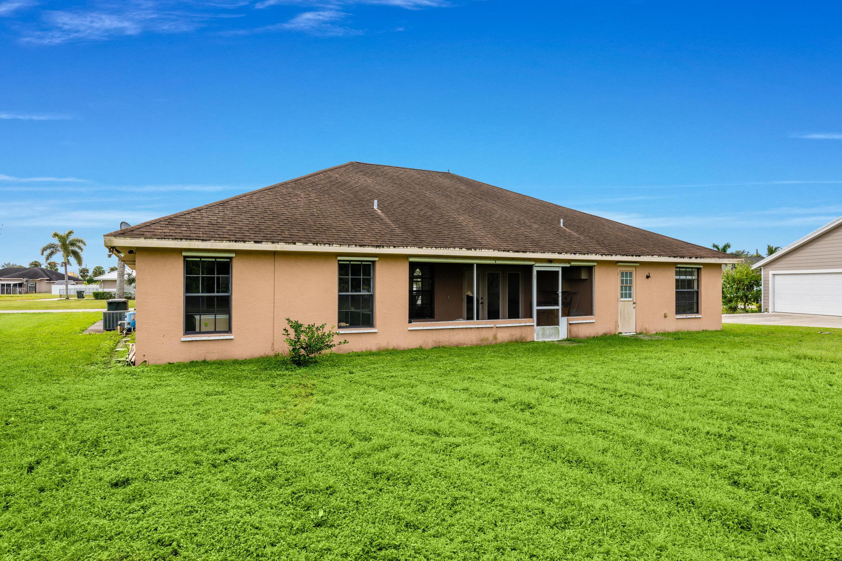 907 Sawgrass Street Clewiston, FL 33440 - Photo 27 of 60 a front view of a house with a garden and porch