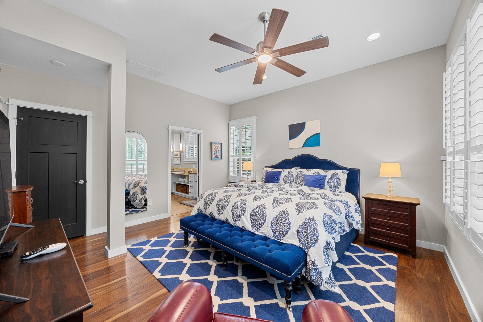3907 Becker Avenue Austin, TX 78751 - Photo 17 of 37 Primary bedroom featuring wood floors, en suite bathroom, closet, ceiling fan, recessed lighting, baseboards and high ceilings.