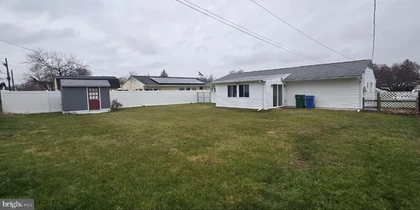 a view of a house with a big yard and large trees