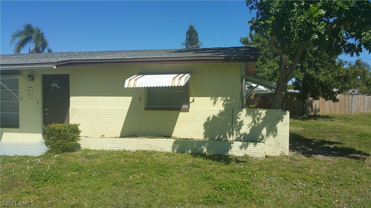 207 Jasmine Road West Lehigh Acres, FL 33936 - Photo 7 of 25 a front view of a house with a yard
