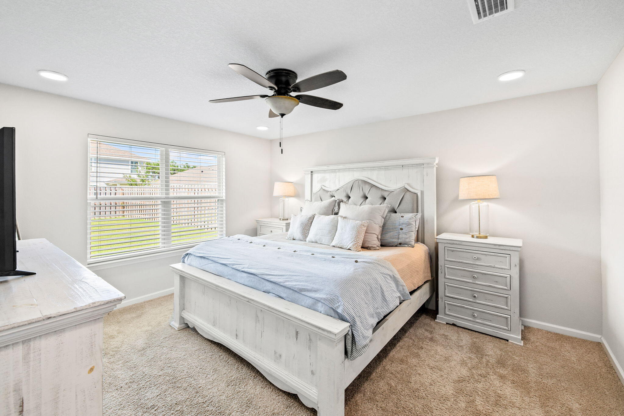 245 This Way Freeport, FL 32439 - Photo 17 of 46 a spacious bedroom with a bed and a chandelier