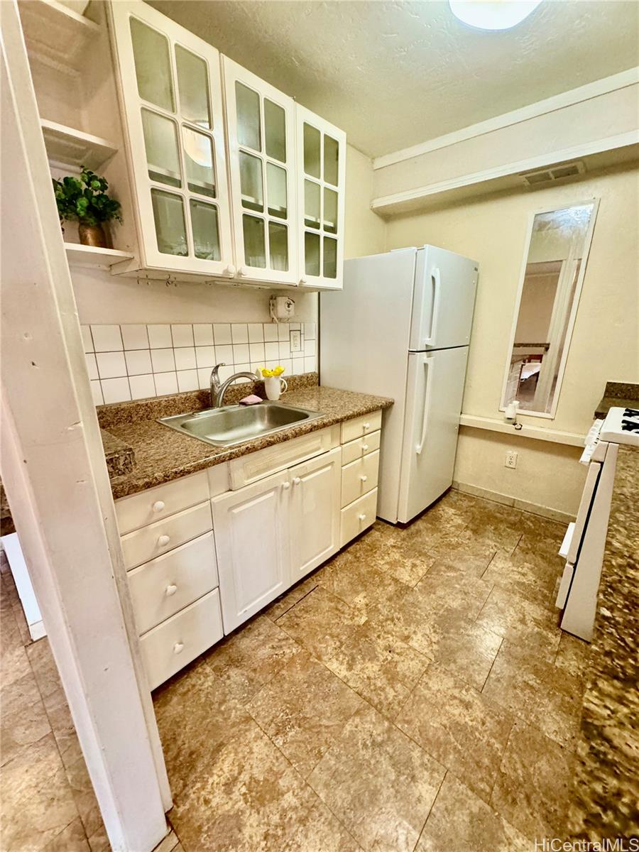 87-122 Helelua Street, Unit C201 Waianae, HI 96792 - Photo 6 of 19 a kitchen with a stove a sink and a refrigerator