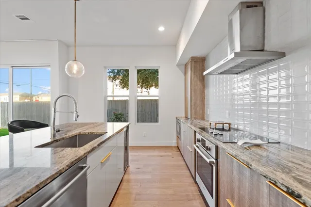 a kitchen with granite countertop a sink and a stove