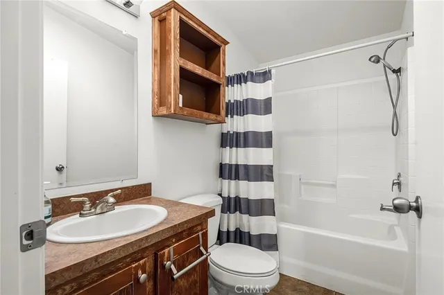 a view of a refrigerator in kitchen and an empty room