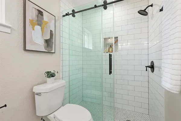 a bathroom with a toilet and a shower