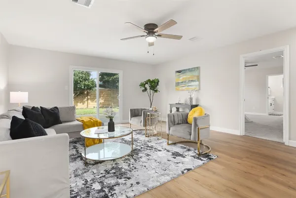 a living room with furniture and a wooden floor