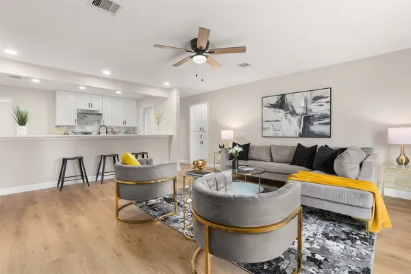 a living room with furniture and kitchen view