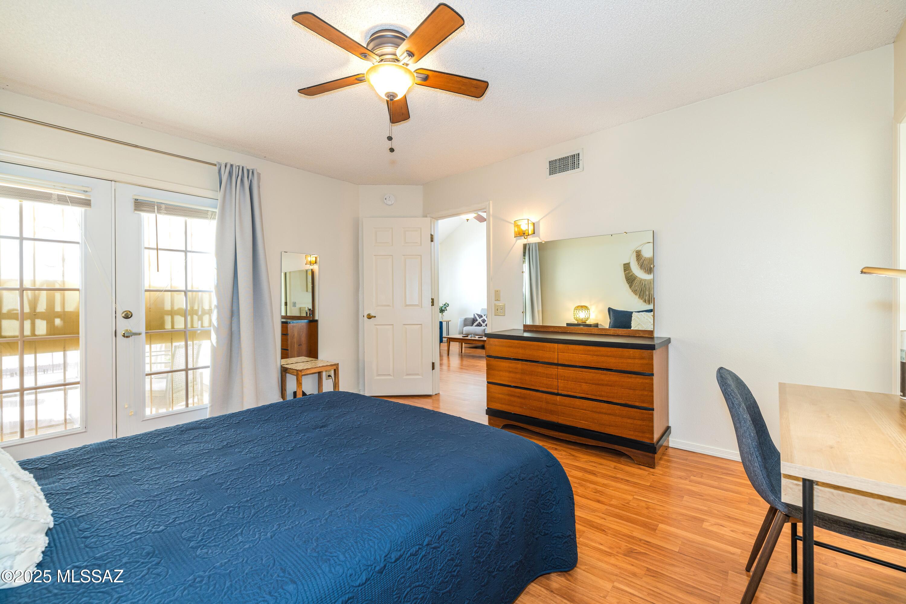 1200 East River Road, Unit G88 Tucson, AZ 85718 - Photo 7 of 13 a bedroom with a bed and a chandelier