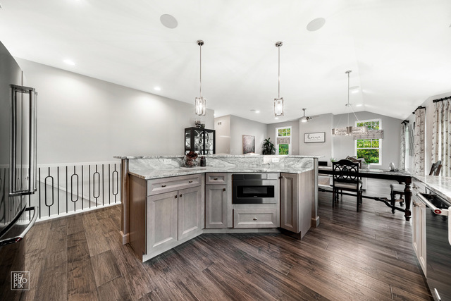 12854 Rosa Lane Lemont, IL 60439 - Photo 3 of 17 a kitchen with stainless steel appliances kitchen island a stove a sink a center island and a wooden floor