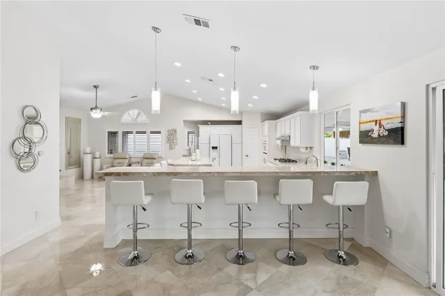 a kitchen with stainless steel appliances kitchen island sink stove and cabinets