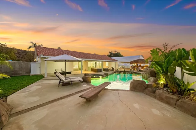 a view of a patio with couches and table under an umbrella