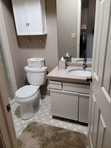 a bathroom with a toilet sink and mirror