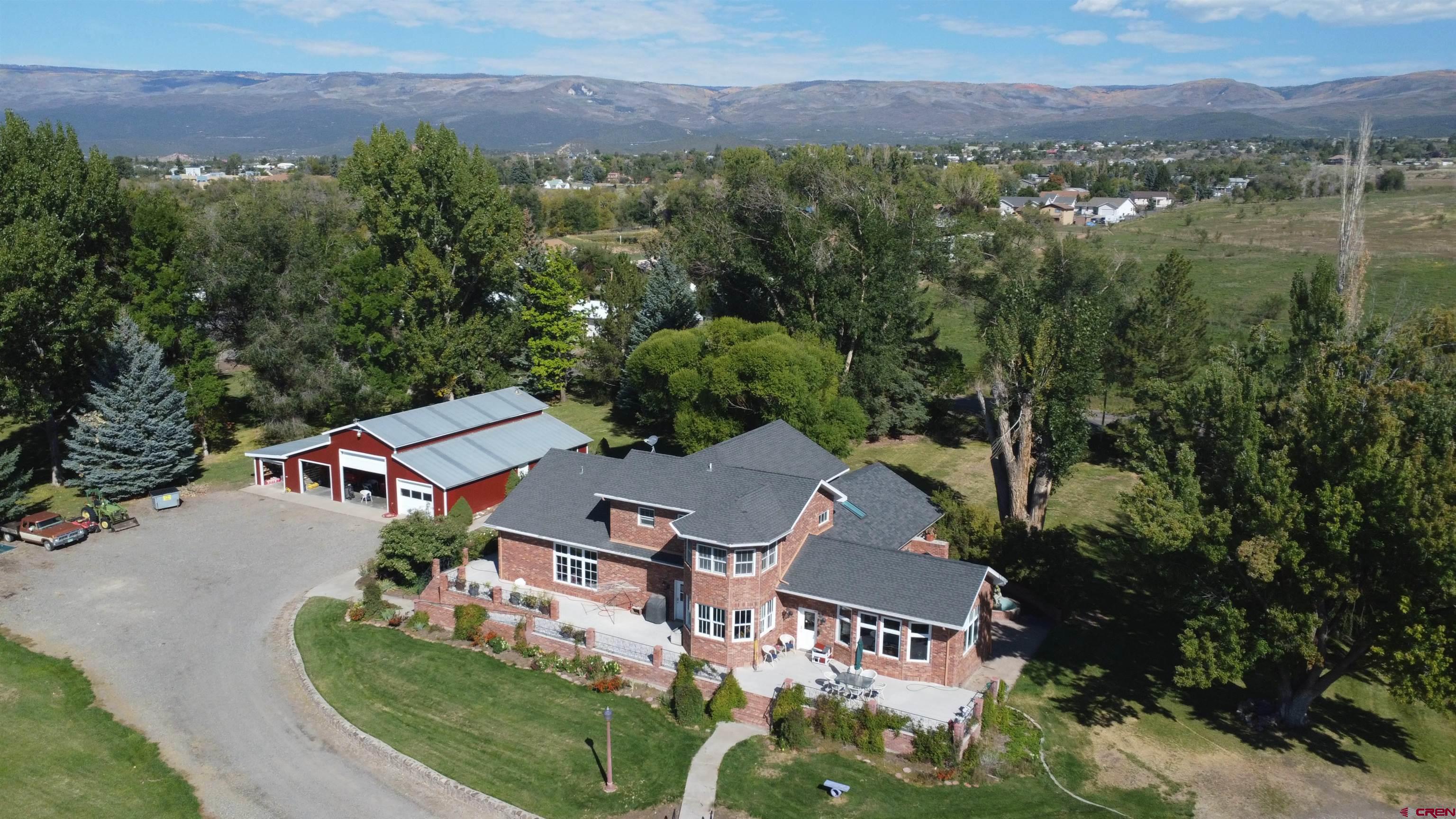 an aerial view of residential houses with outdoor space and trees