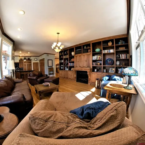 a living room with furniture a fireplace and a chandelier