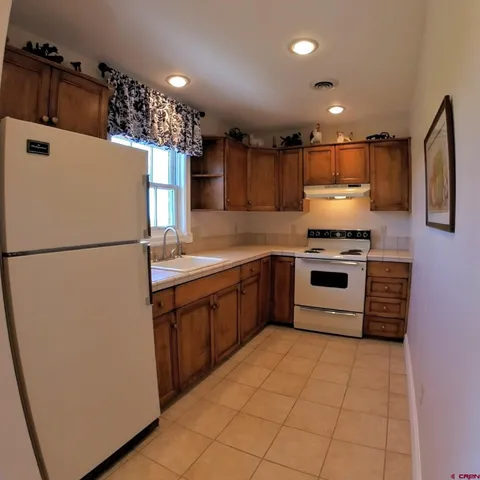 a kitchen with stainless steel appliances granite countertop a refrigerator a stove a sink and a microwave