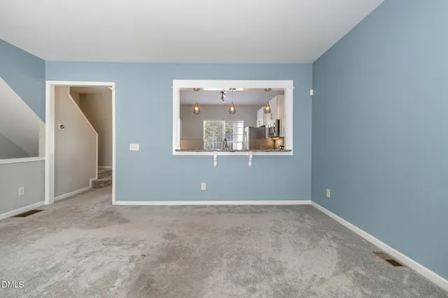 an empty room with mirror and windows