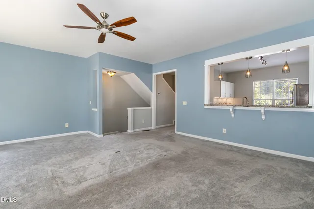 an empty room with fan and windows