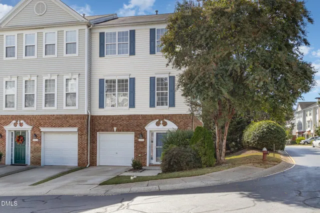 a front view of a house with yard and trees around