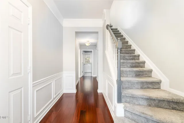 a view of a hallway with wooden floor and staircase