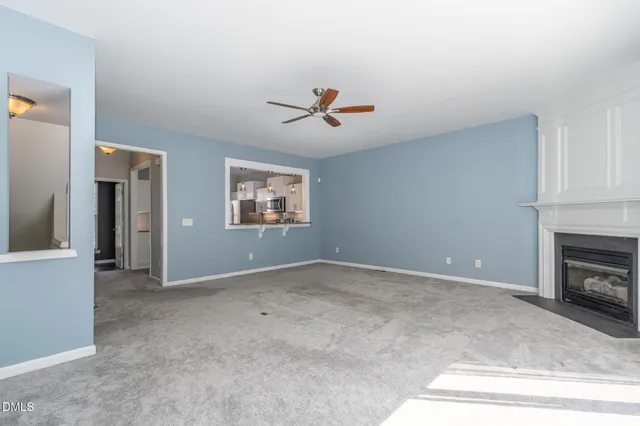 an empty room with windows and fireplace