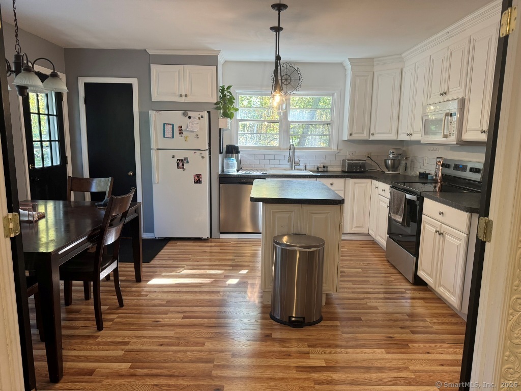 1166 Spindle Hill Road Wolcott, CT 06716 - Photo 3 of 29 a kitchen with stainless steel appliances granite countertop a refrigerator a stove top oven a sink dishwasher and white cabinets with wooden floor