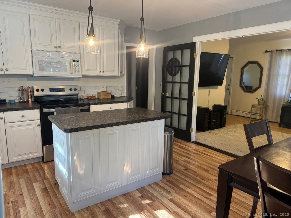 1166 Spindle Hill Road Wolcott, CT 06716 - Photo 7 of 29 a kitchen with stainless steel appliances granite countertop a refrigerator a stove and a wooden floors