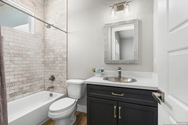 a bathroom with a sink toilet vanity mirror and bathtub