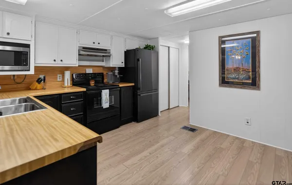 a bedroom with a bed a chandelier and dresser