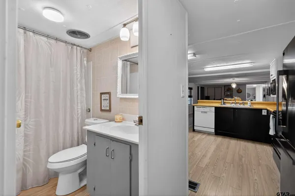 a bathroom with a sink vanity mirror and toilet