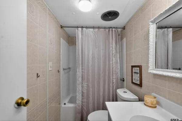 a bathroom with a sink a toilet and shower curtain
