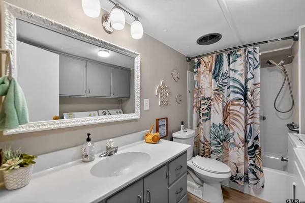 a bedroom with a large bed chandelier and a window