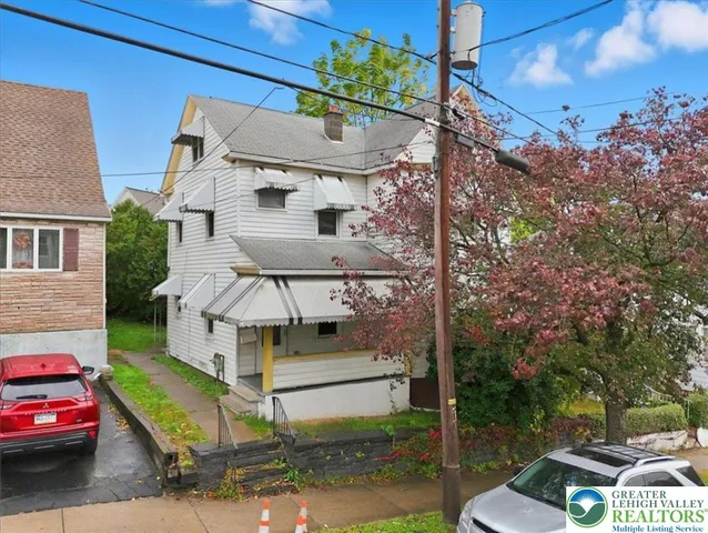 a white house that has a tree in front of it