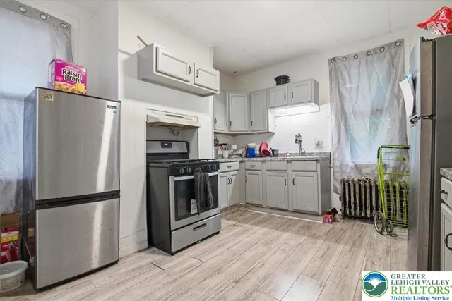 a kitchen with a refrigerator sink and wooden floor