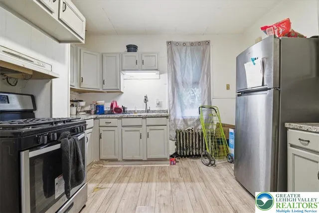 a kitchen with granite countertop a refrigerator stove and sink