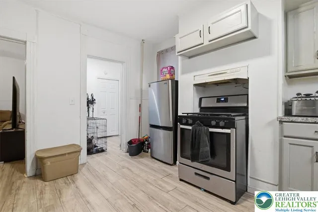 a kitchen with stainless steel appliances a stove refrigerator and a refrigerator