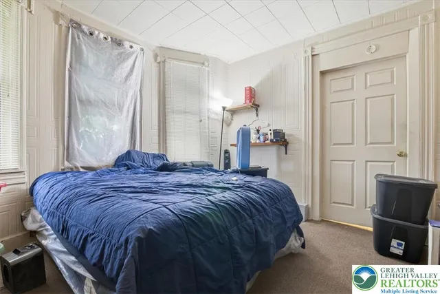 a bedroom with a bed and a flat tv screen