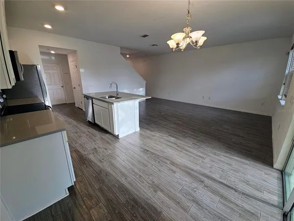 a kitchen with stainless steel appliances granite countertop a sink a stove and a wooden floors