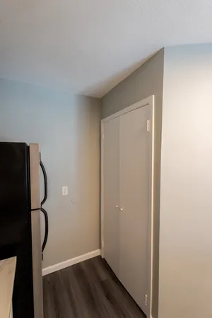 a view of a room with wooden floor and white walls