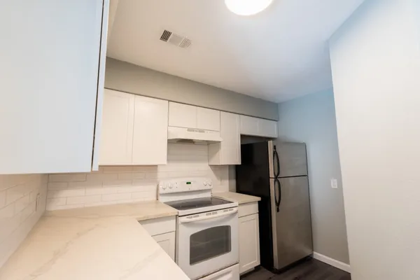 a kitchen with a stove a refrigerator and cabinets