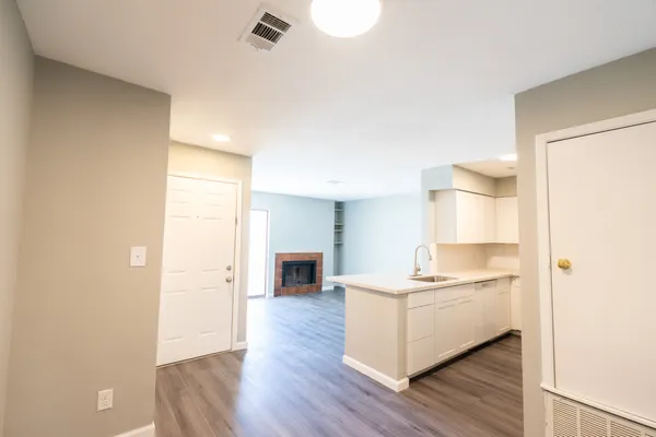 a view of kitchen with sink and refrigerator