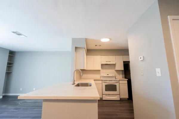 a kitchen with a white stove top oven and sink